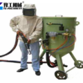 operator in blasting protective gear with sandblasting machine