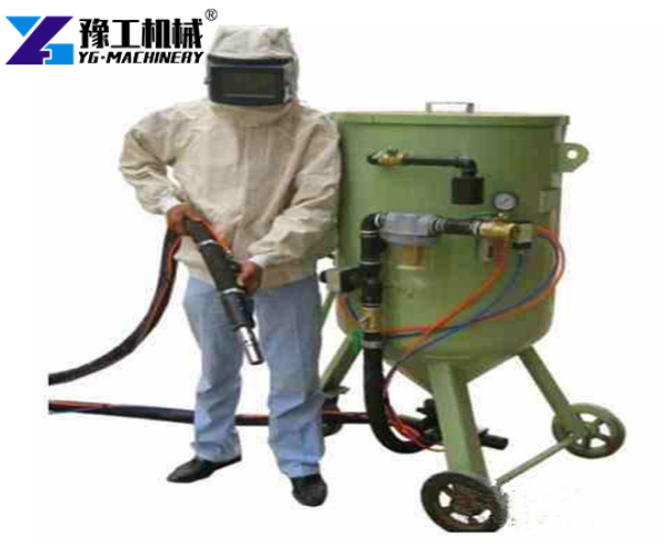 operator in blasting protective gear with sandblasting machine